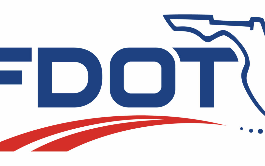 The image shows the logo of the Florida Department of Transportation (FDOT). It features the acronym "FDOT" in bold blue letters, with a blue outline of the state of Florida on the top right and two curved red lines underneath, highlighting its significance in areas like Palm Coast and Flagler County.