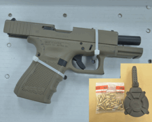 A tan semi automatic handgun secured with zip ties is displayed on a white surface Inset: a bag of bullets and a black magazine loader are shown on a beige background