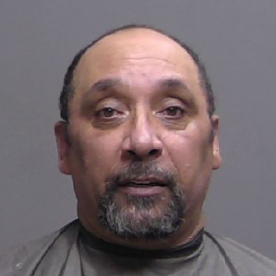 A middle aged man with a receding hairline, short dark hair, and a goatee, wearing a gray shirt, poses against a plain gray background A middle aged man with a receding hairline, short dark hair, and a goatee, wearing a gray shirt, poses against a plain gray background