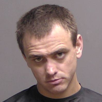 A headshot of a man with short brown hair looking forward A headshot of a man with short brown hair looking forward